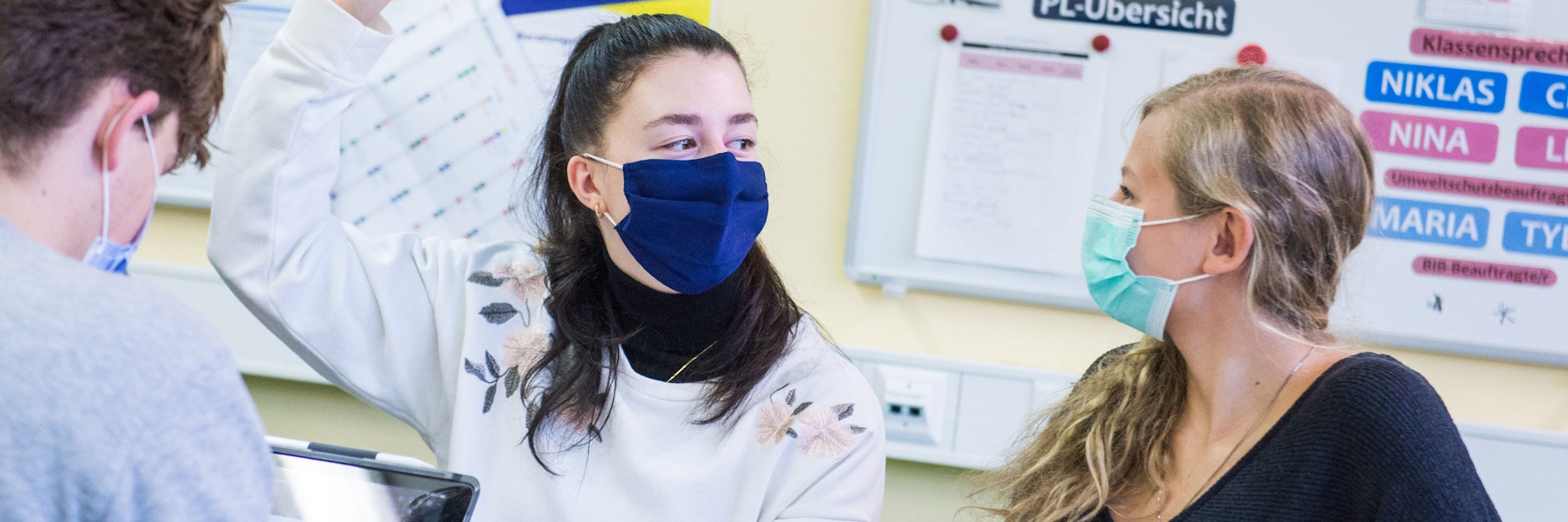 Schüler sitzen mit Mund-Nasen-Bedeckungen im Unterricht.&nbsp;