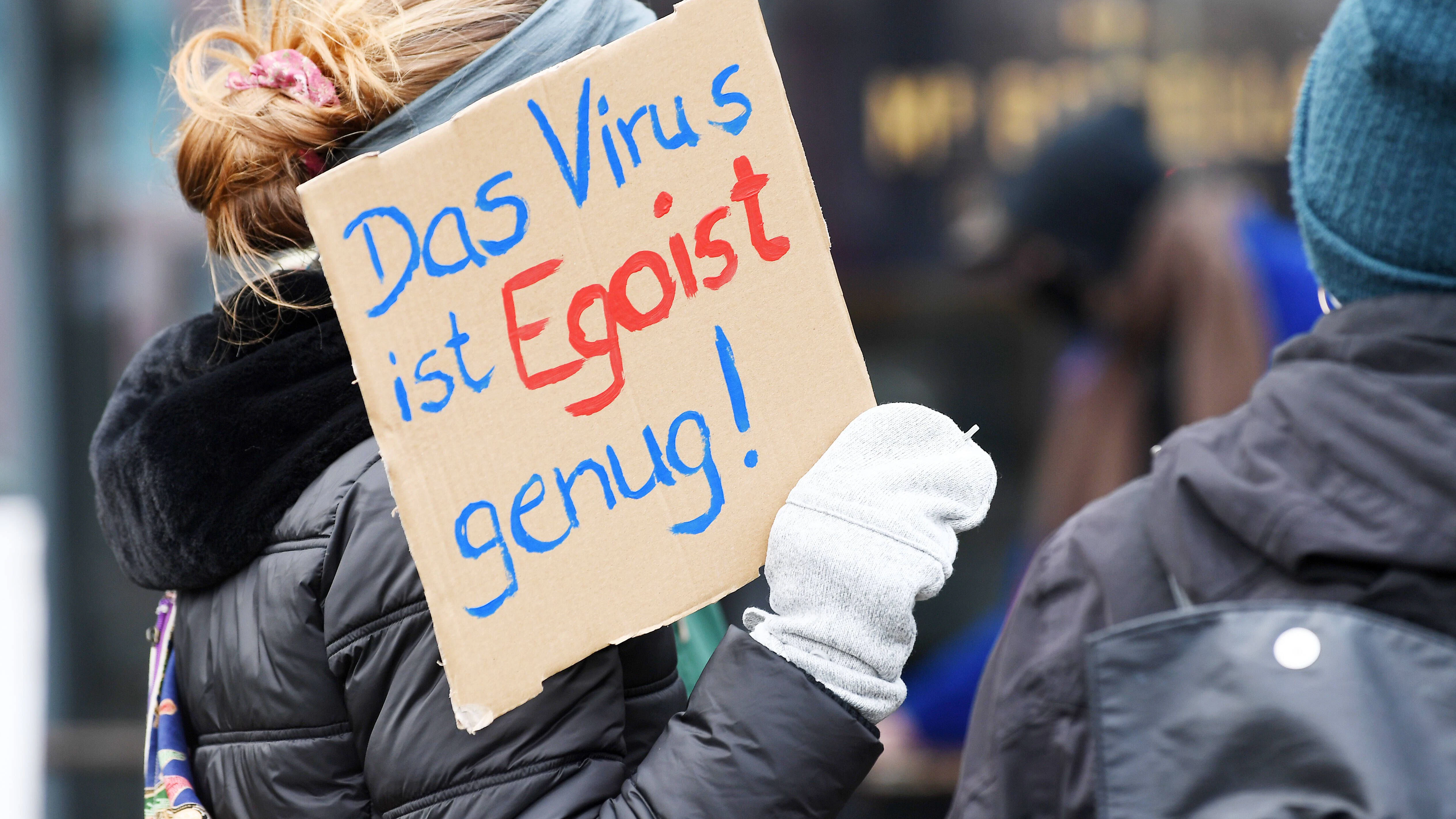Eine Teilnehmerin der Gegendemonstration "Kritisch bleiben, Abstand halten, Freiheit solidarisch leben" gegen die Querdenken-Bewegung zeigt ein Schild mit der Aufschrift " Das Virus ist Egoist genug".&nbsp;