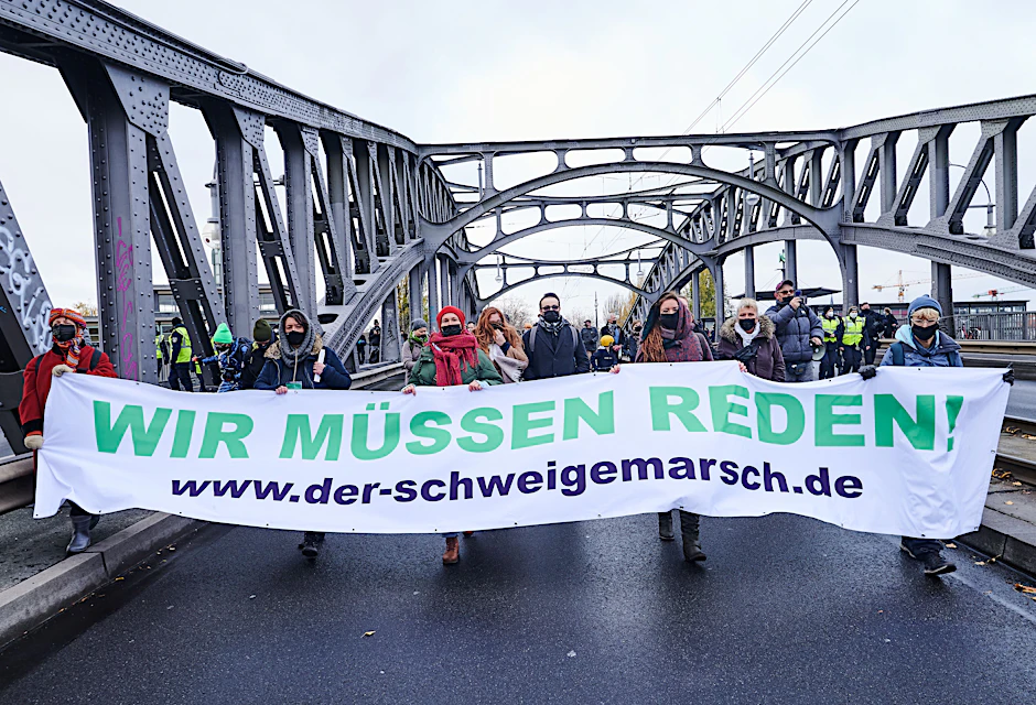 Teilnehmende des Schweigemarschs auf der Bornholmer Brücke in Berlin.