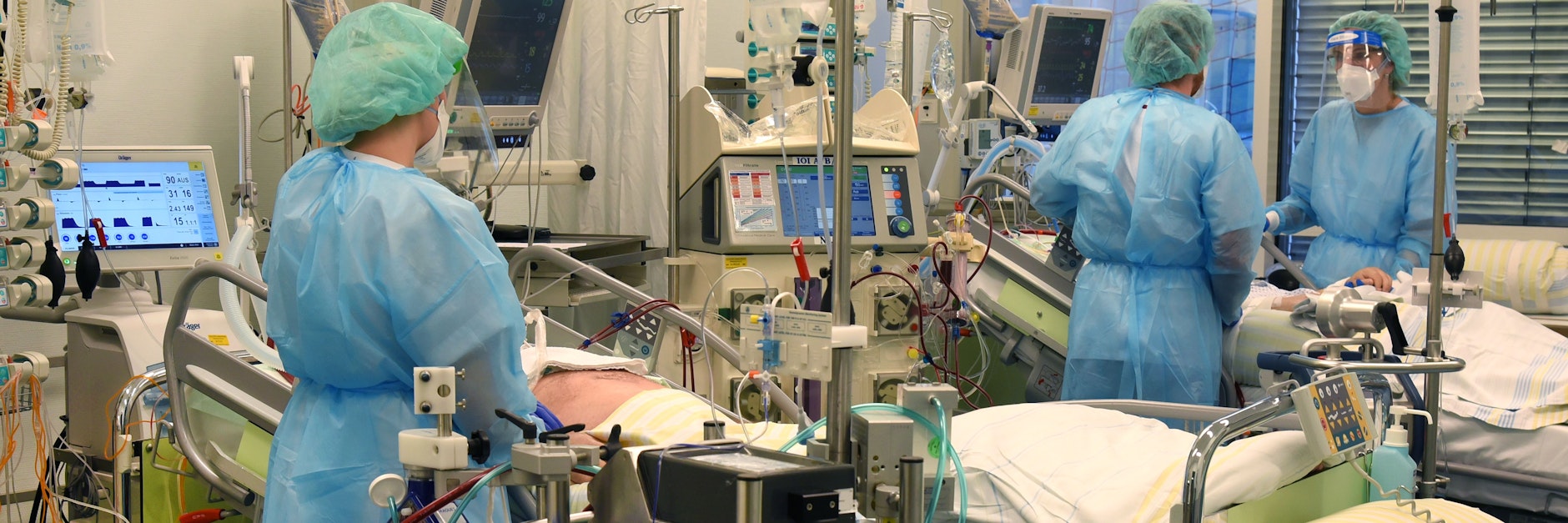 Maschinen, Bildschirme, Schläuche, Kabel: ein Arzt und zwei Schwestern an den Betten zweier Schwerstkranker in der Covid-19-Station der Uniklinik Leipzig.