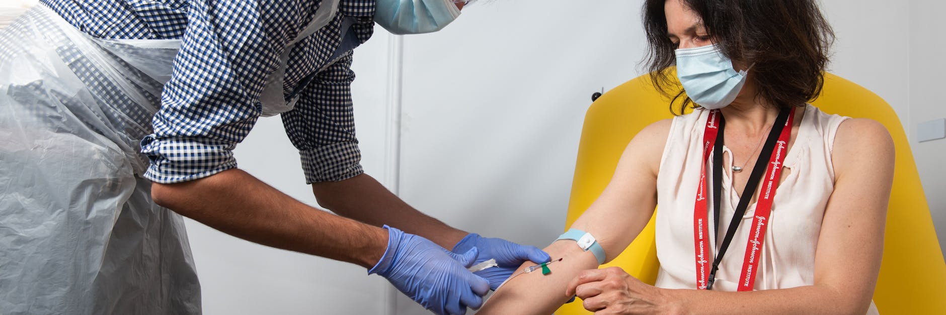 Einer Freiwilligen wird der Impfstoff von AstraZeneca und der Universität Oxford verabreicht. Eine offizielle Impfpflicht soll es nicht geben - aber kommt sie durch die Hintertür?