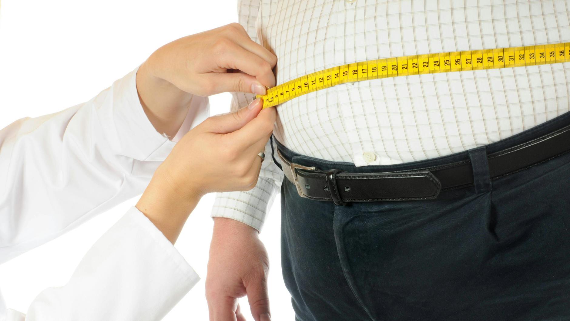 Eine Ärztin misst den Bauchumfang eines Mannes (Symbolbild).