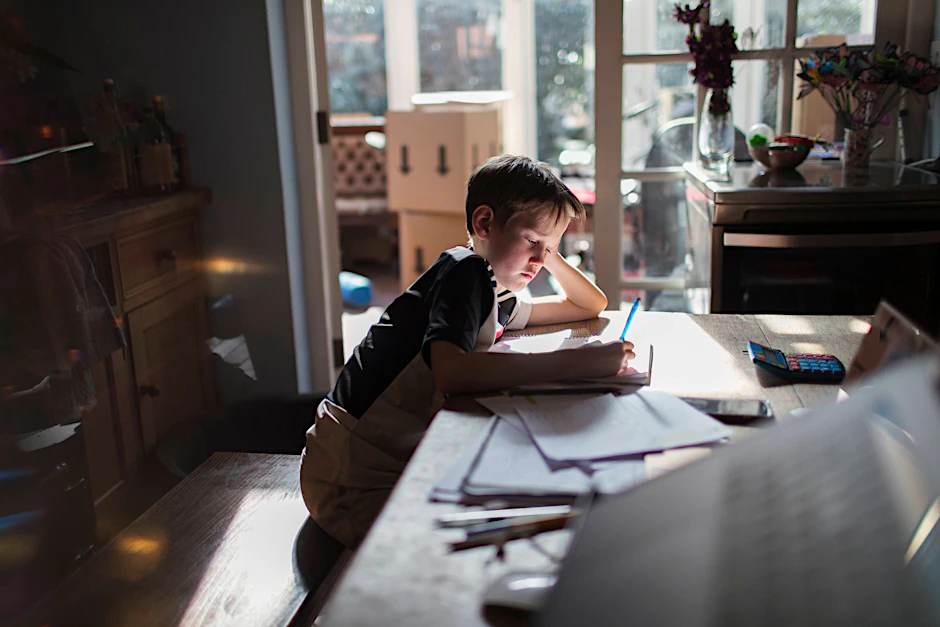 Zurück zum Homeschooling? Jedenfalls teilweise. Ein Junge beugt sich über seine Aufgaben.