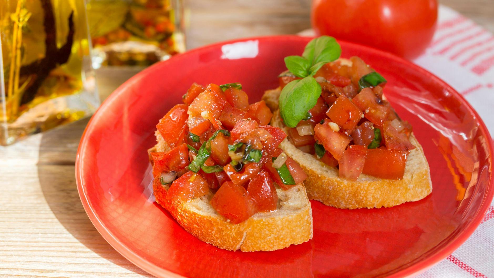 Ein roter Teller mit Bruschetta.