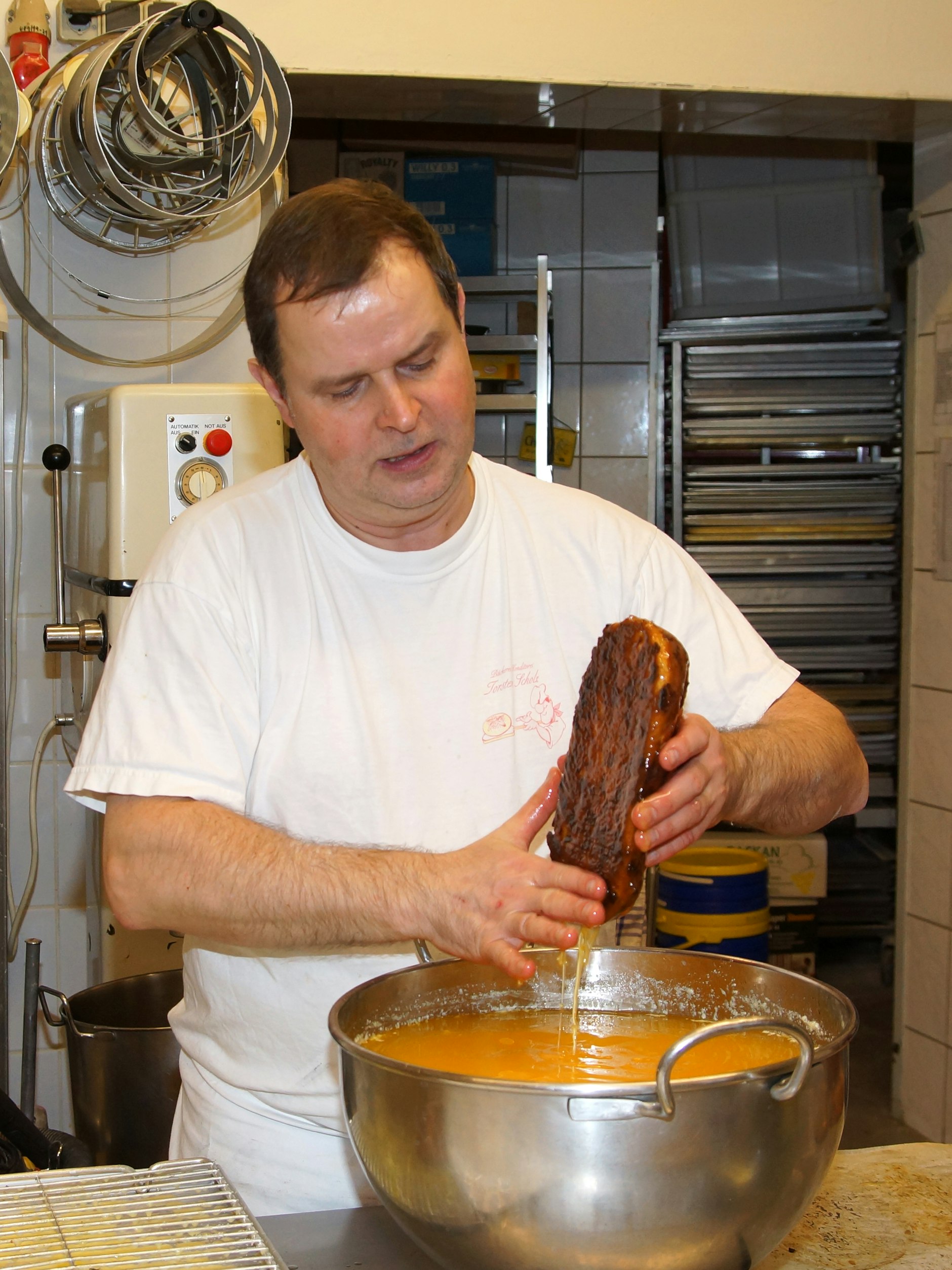 Bäckermeister Thorsten Scholz tunkt seine Stollen komplett in Butter.