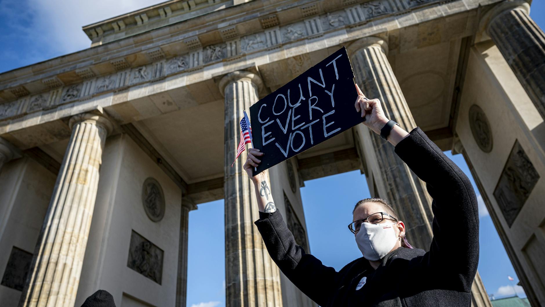 Eine Teilnehmerin auf der Kundgebung unter dem Motto „Friedlicher Übergang der Präsidentschaft und eine demokratische USA“ vor dem Brandenburger Tor in Berlin