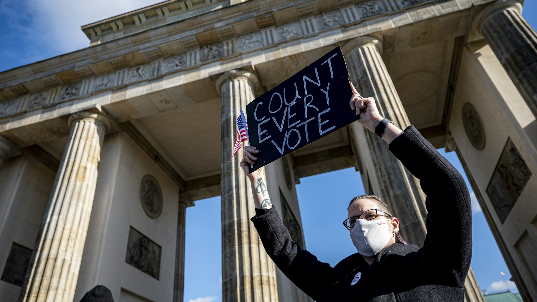 Eine Teilnehmerin auf der Kundgebung unter dem Motto „Friedlicher Übergang der Präsidentschaft und eine demokratische USA“ vor dem Brandenburger Tor in Berlin
