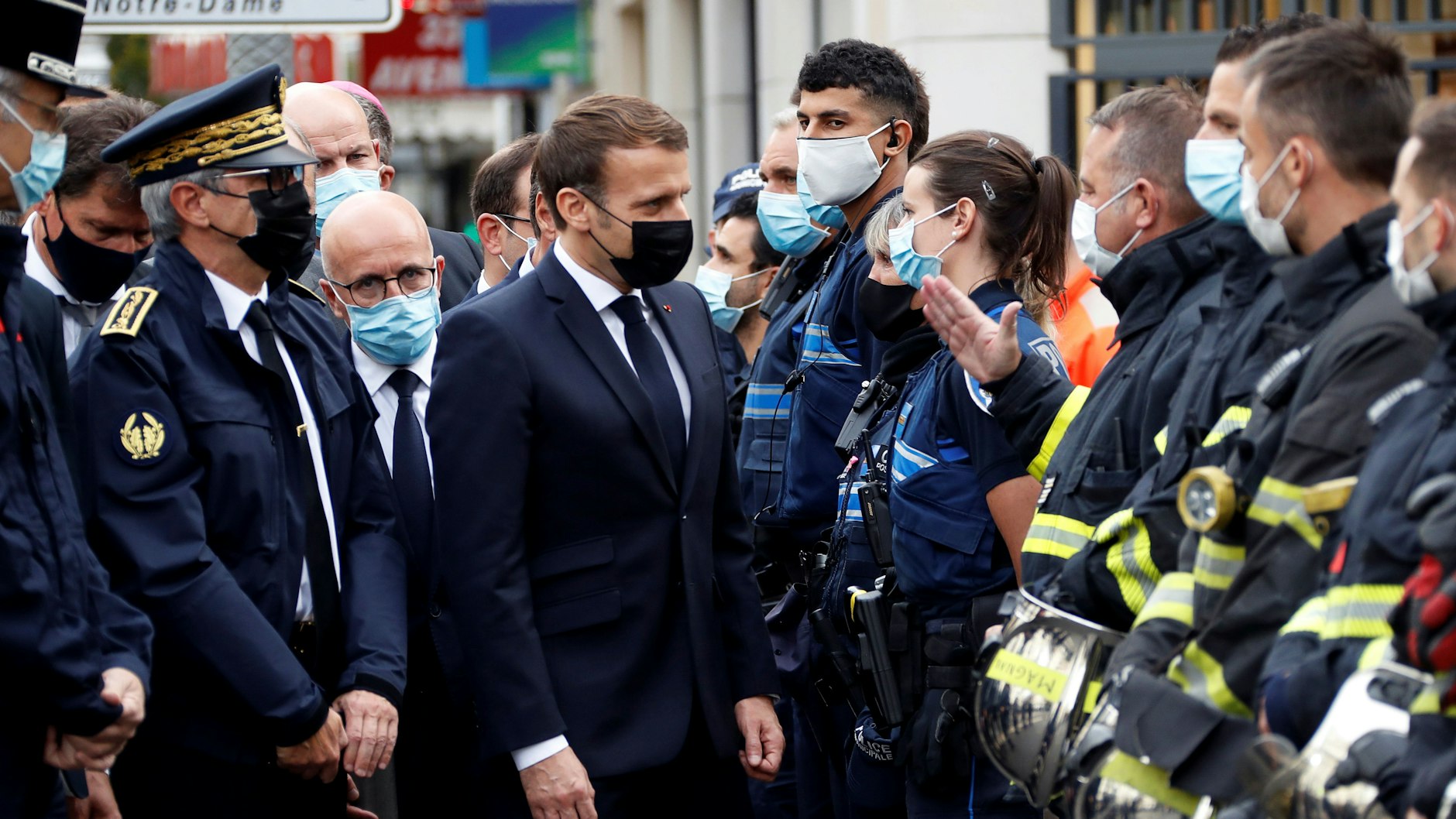 Emmanuel Macron (M.), Präsident von Frankreich, spricht nach einer Messerattacke in der Kirche Notre-Dame in Nizza mit Polizeibeamten. Bei dem Attentat hat es mindestens drei Tote und mehrere Verletzte gegeben.