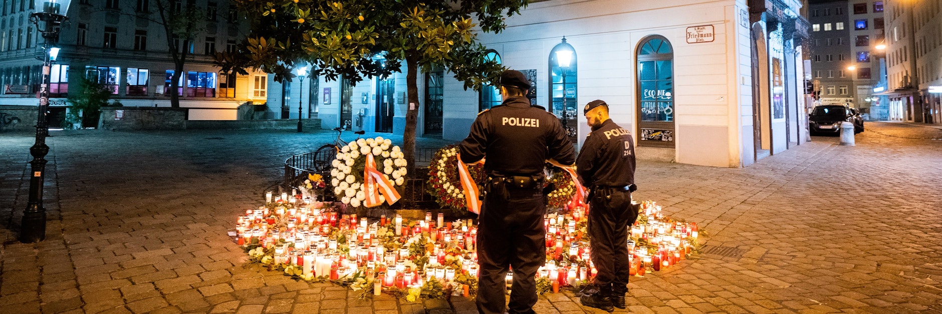 Polizisten stehen vor Kerzen am Tatort Desider-Friedmann-Platz in der Wiener Innenstadt. Bei dem Anschlag mit vier Todesopfern am Montagabend, den 2. November, hat der Täter nach Erkenntnissen der Sicherheitsbehörden allein gehandelt. 