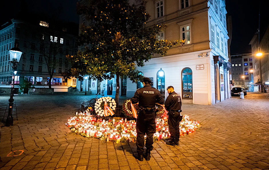 Polizisten stehen vor Kerzen am Tatort Desider-Friedmann-Platz in der Wiener Innenstadt. Bei dem Anschlag mit vier Todesopfern am Montagabend, den 2. November, hat der Täter nach Erkenntnissen der Sicherheitsbehörden allein gehandelt.&nbsp;