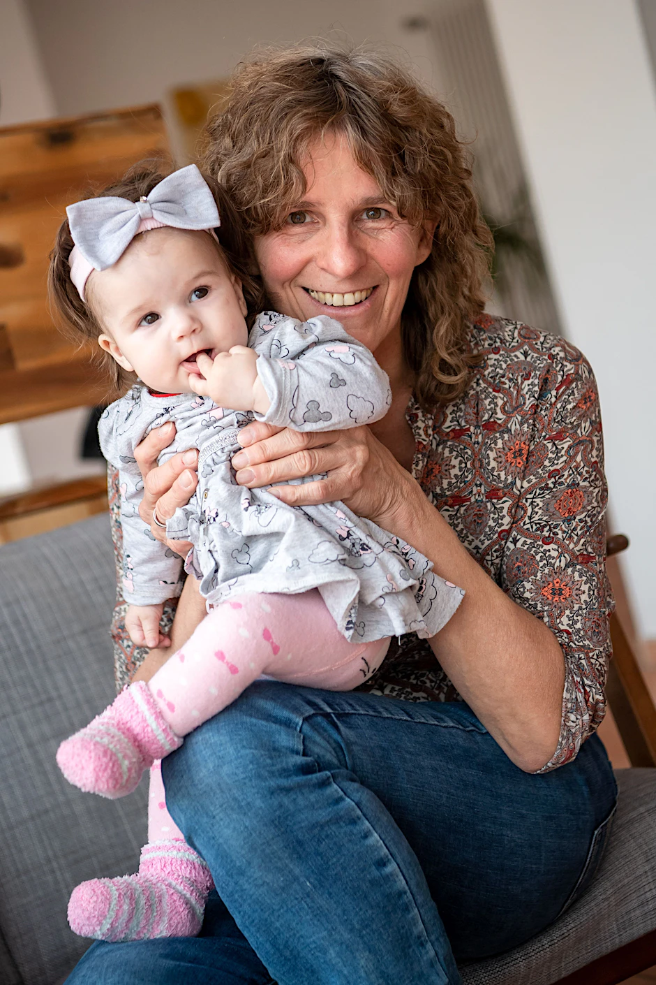 Ellen Matzdorf, Bestatterin und Hebamme, sitzt mit Masha auf dem Sofa.