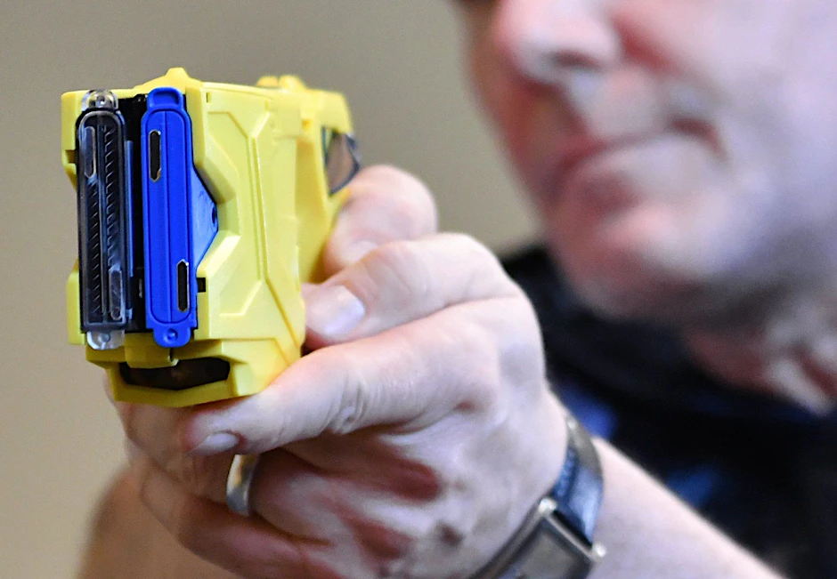 Ein Polizeibeamter zeigt bei einem Pressetermin die Handhabung eines auch als Taser bezeichneten Elektroimpulswaffe.
