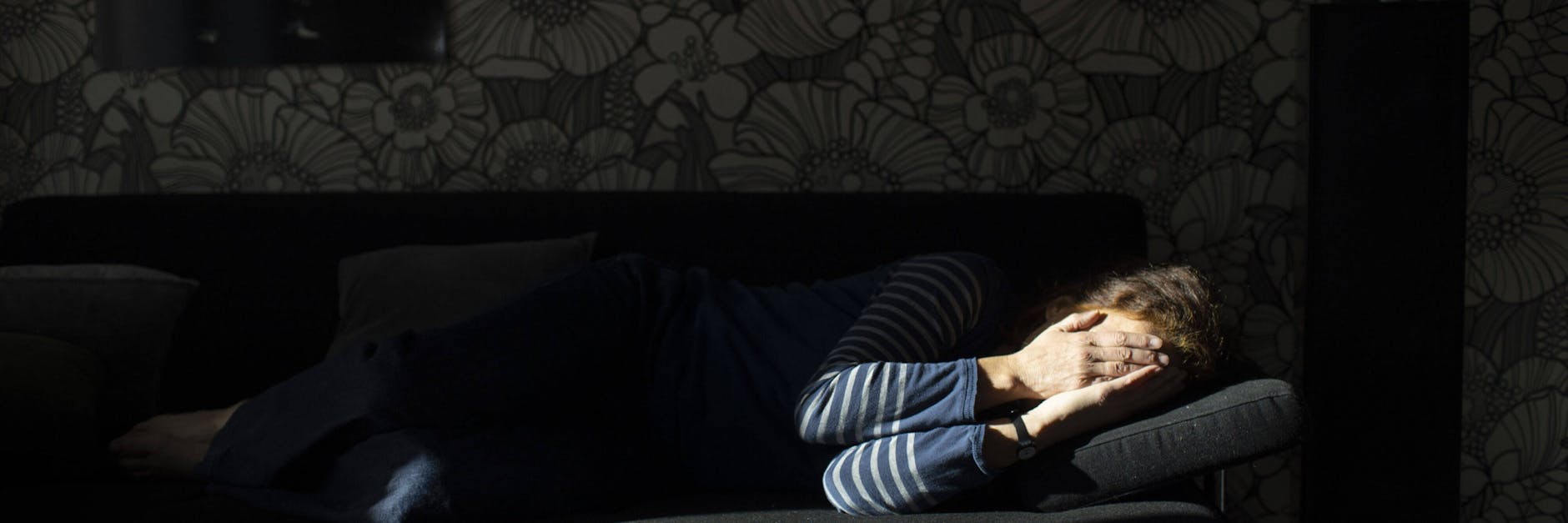 Eine Frau verbirgt ihr Gesicht.