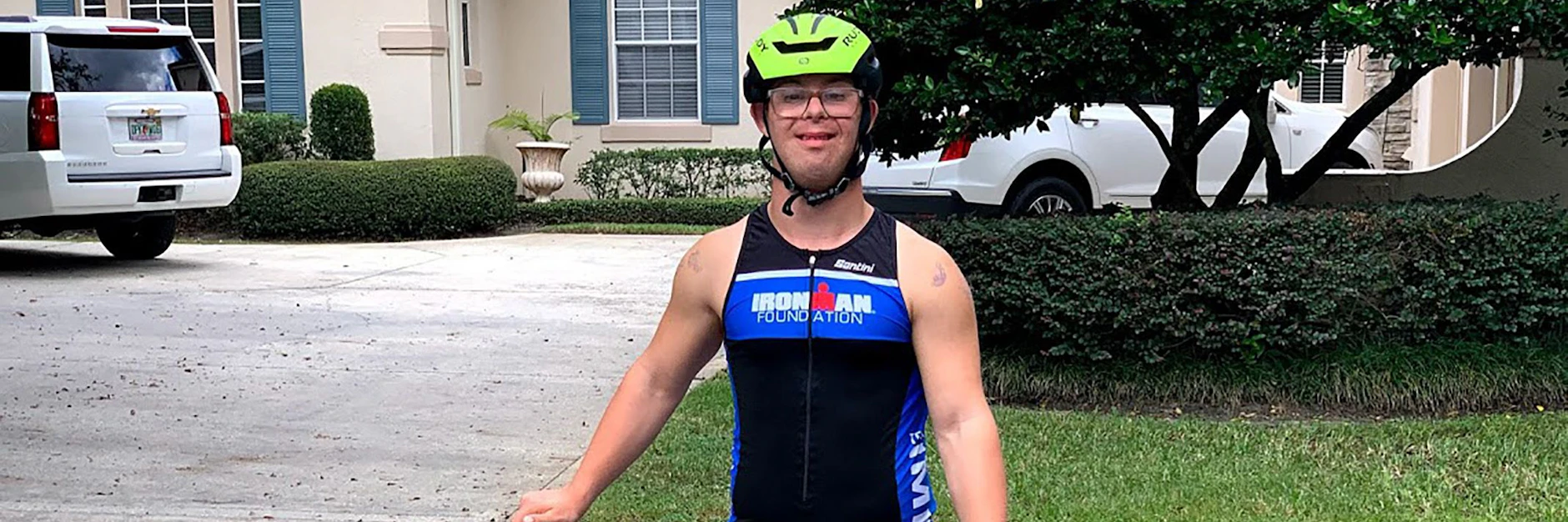 Chris Nikic steht mit Helm und Sportanzug hinter seinem Rennrad.