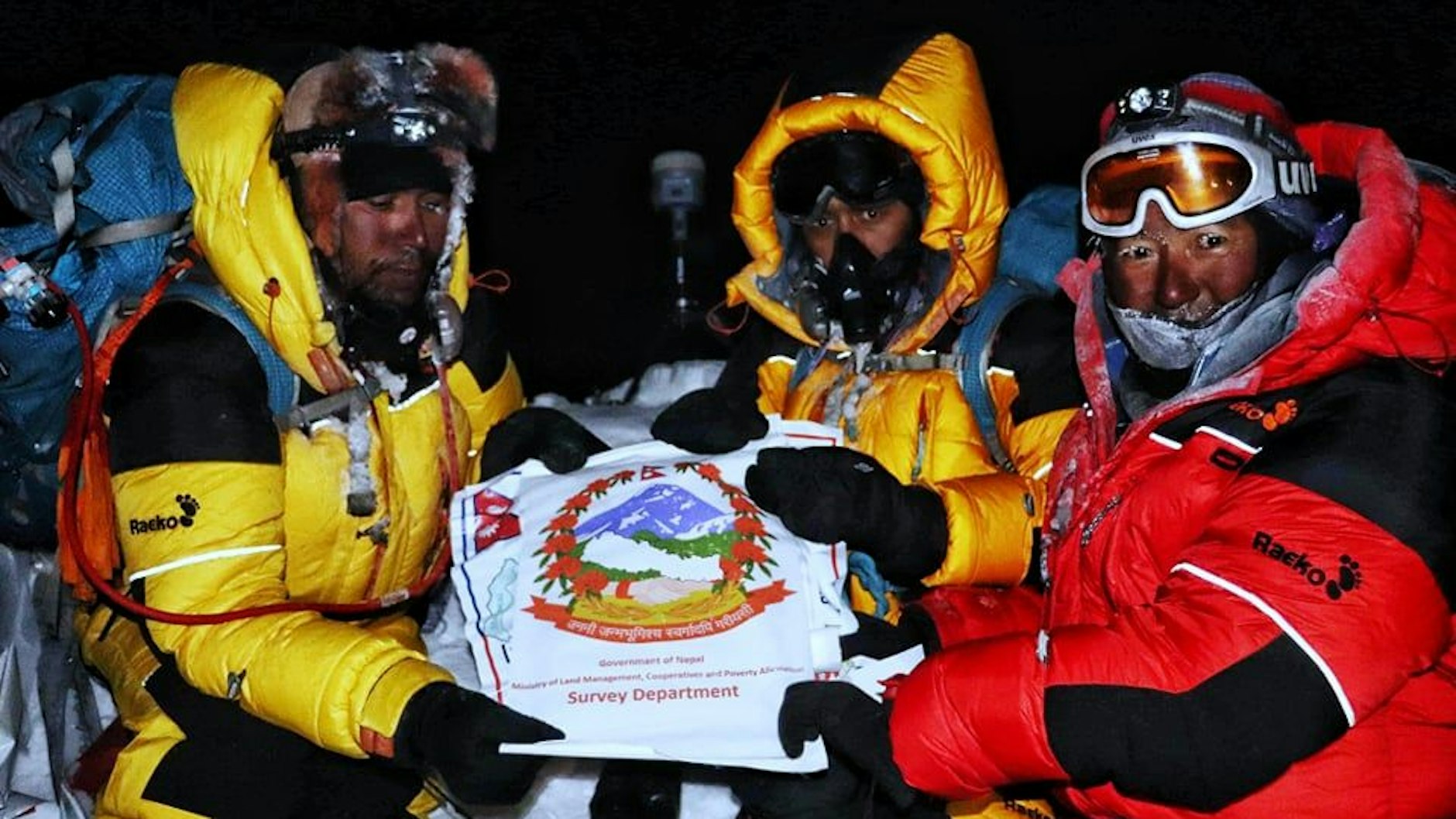 Todeszone oben auf dem Mount Everest: Khim Lal Gautam (li.) und seine Teamkollegen posieren mit einem Transparent des nepalesischen Vermessungsministeriums.