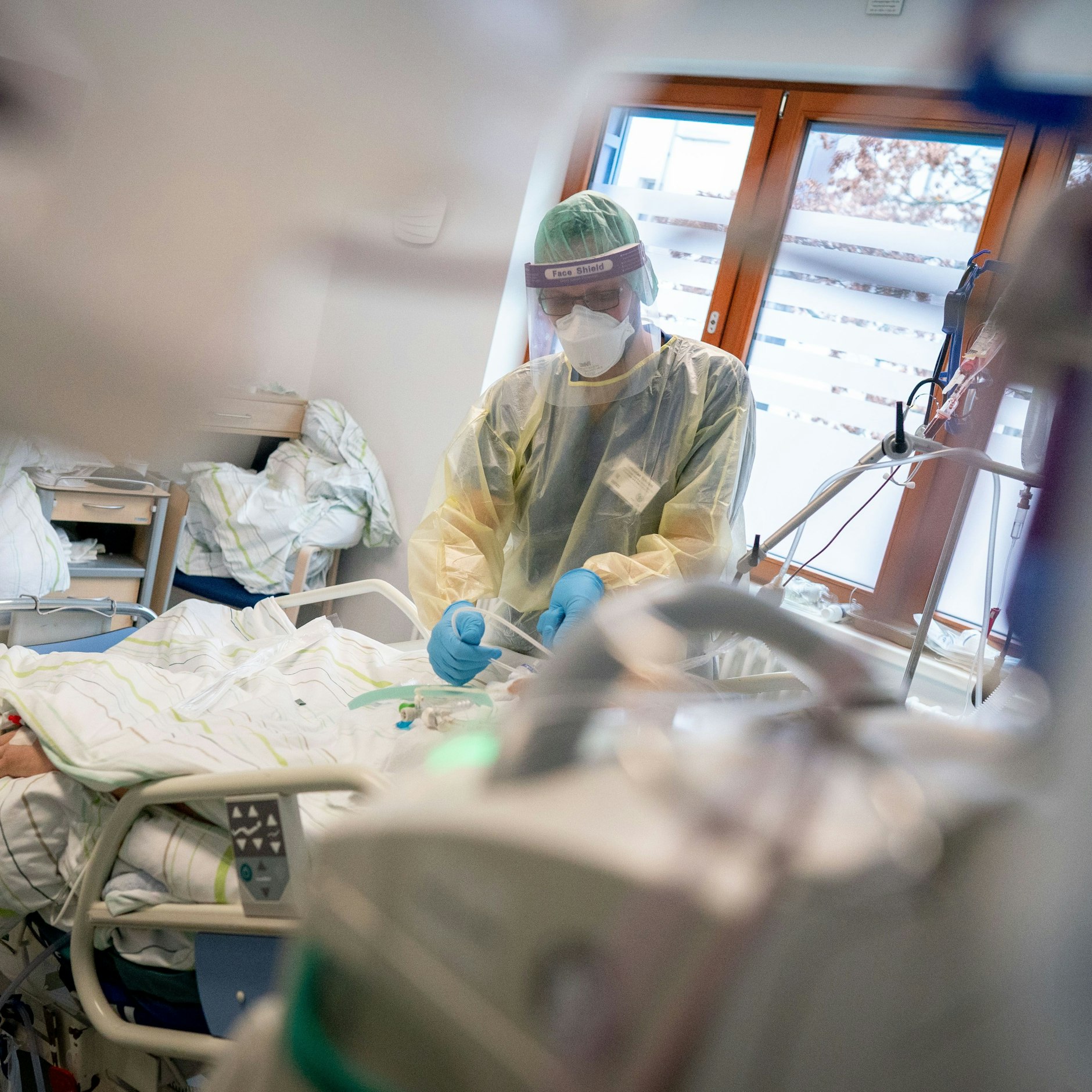 Ein Pfleger betreut auf der Intensivstation eines Krankenhauses einen Corona-Patienten.