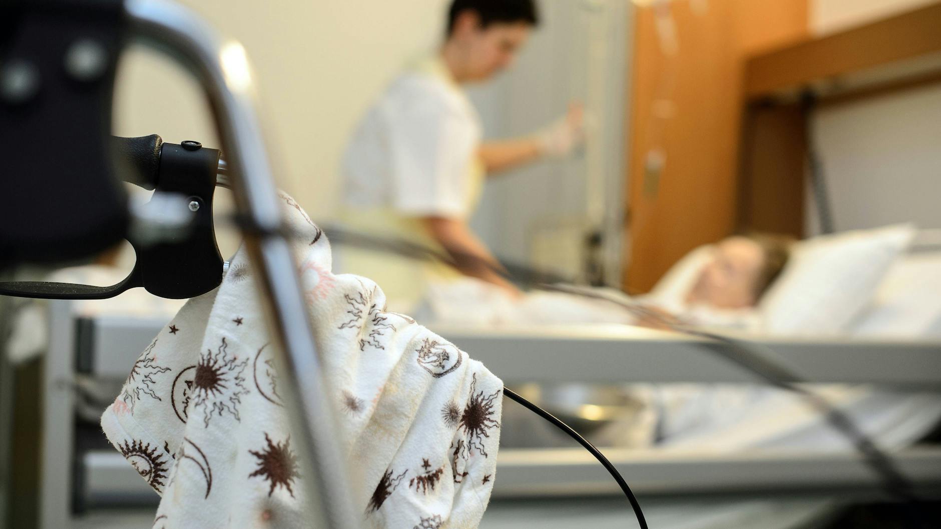 Eine Krankenschwester am Bett eines schwerst kranken Patienten auf einer Palliativstation in einem Krankenhaus.