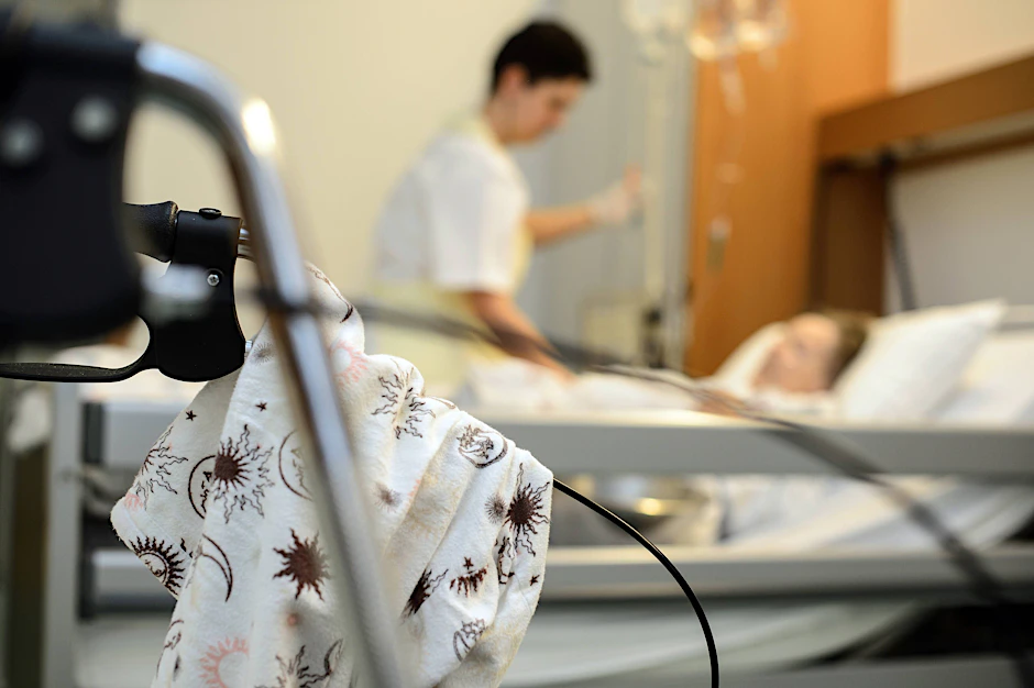 Eine Krankenschwester am Bett eines schwerst kranken Patienten auf einer Palliativstation in einem Krankenhaus.