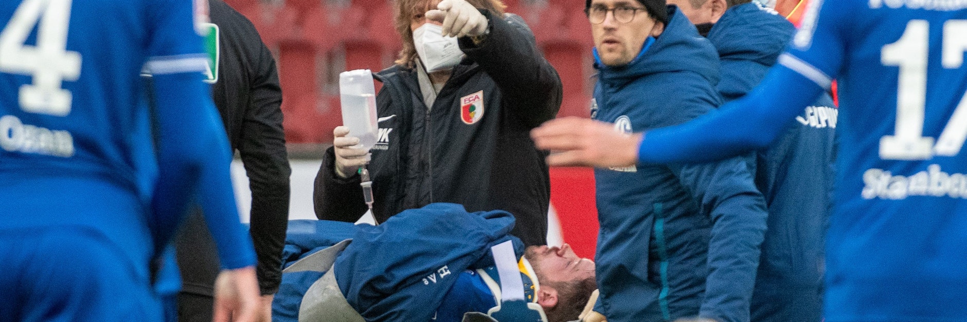 Augsburgs Mannschaftsarzt Andreas Weigel gibt Schalkes Mark Uth eine Infusion. 