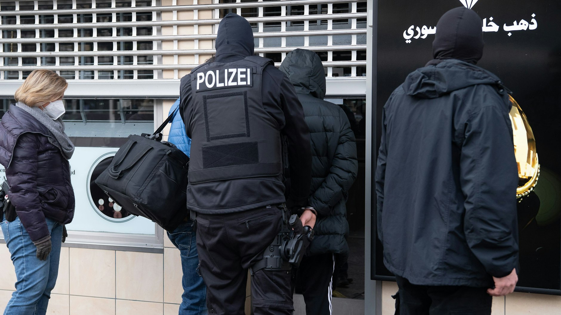 Nach zahlreichen Durchsuchungen verschiedener Objekte in Berlin führen die Beamten einen Mann ab.