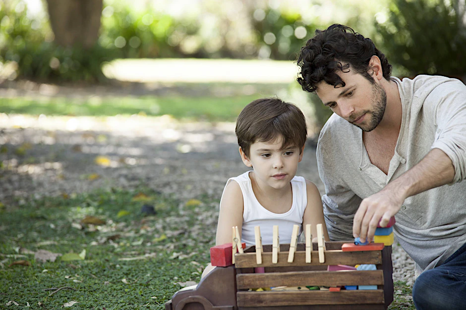 Vater und Sohn spielen im Hof mit improvisiertem Spielzeug.&nbsp;