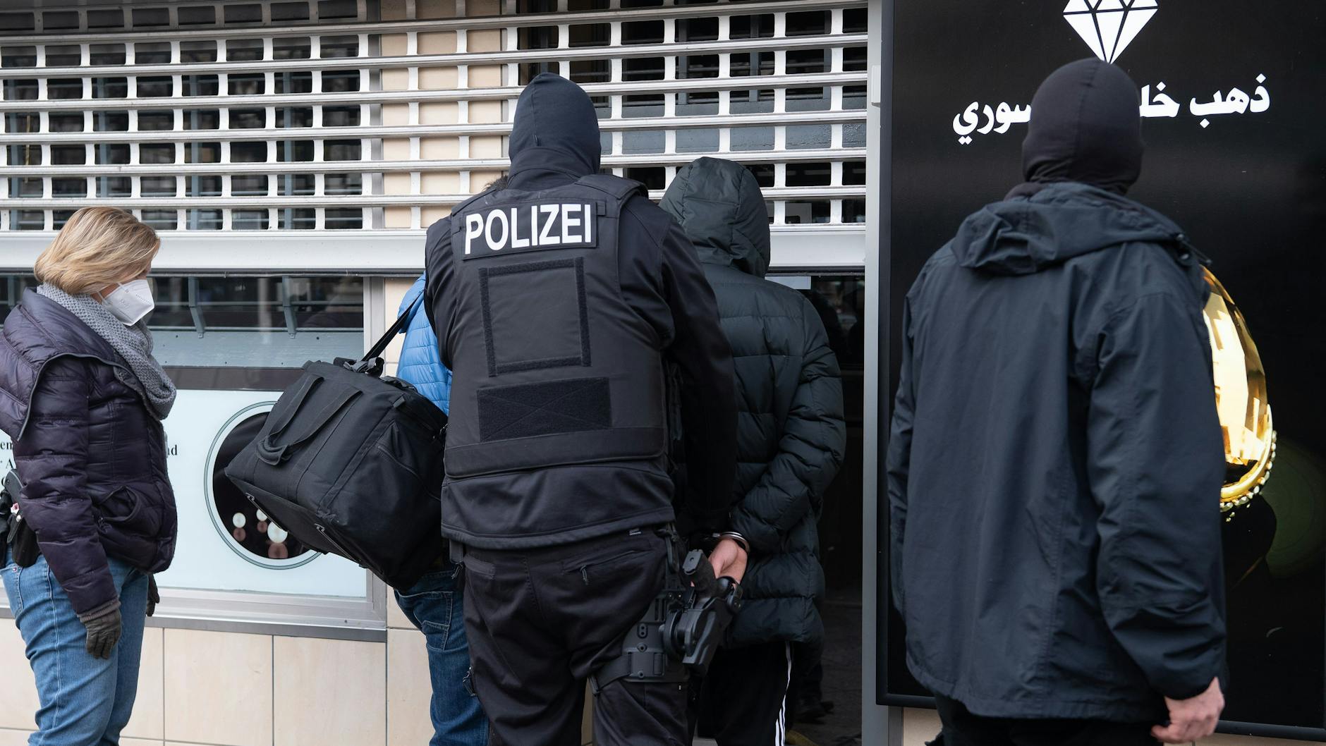 Polizisten betreten einen Juwelier, um Beweismittel zu sichern. 