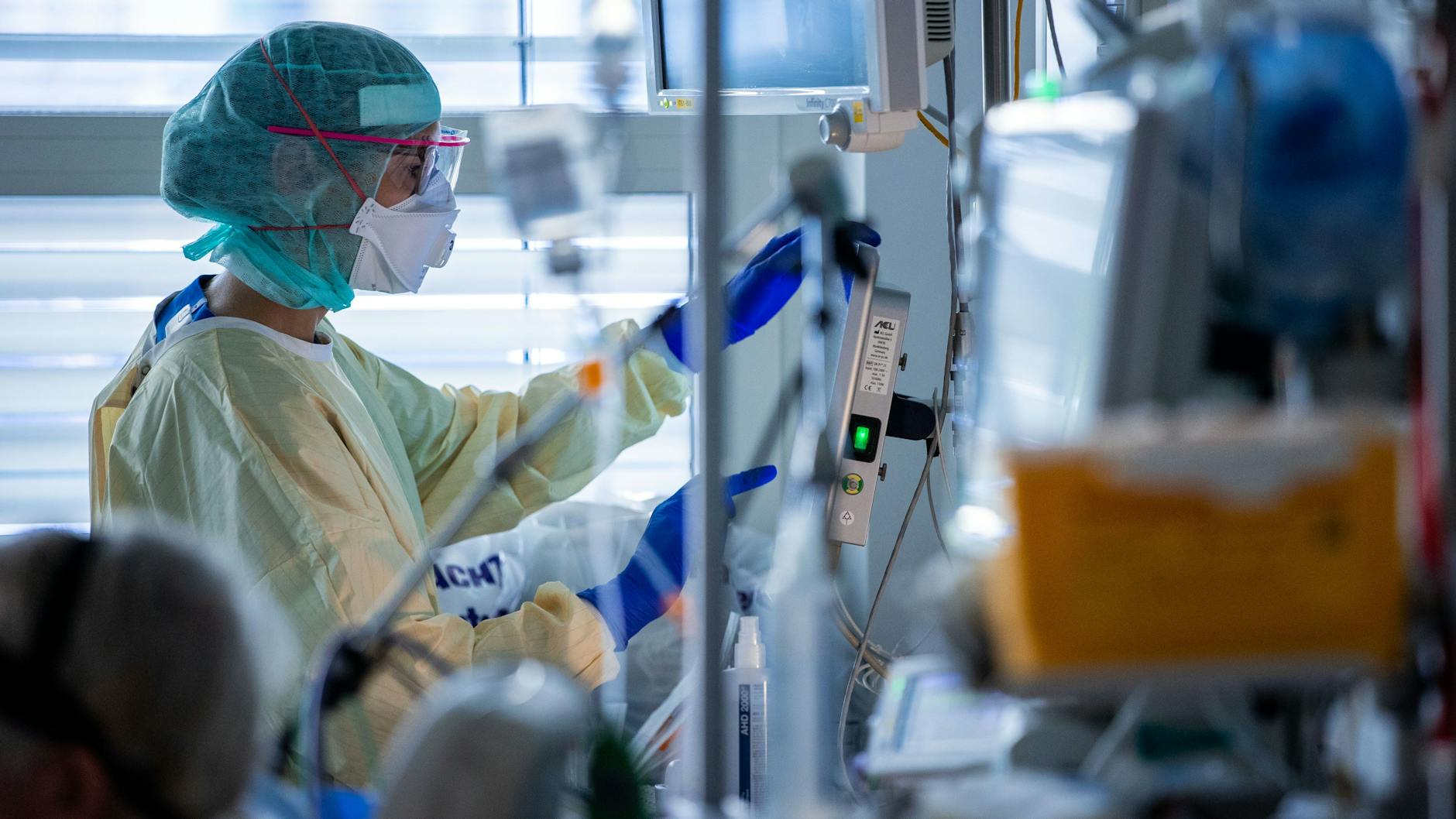 Schwester Franziska Strauß dokumentiert im besonders geschützten Teil der Intensivstation neben dem Bett eines Covid-19-Patienten die Behandlungsschritte.