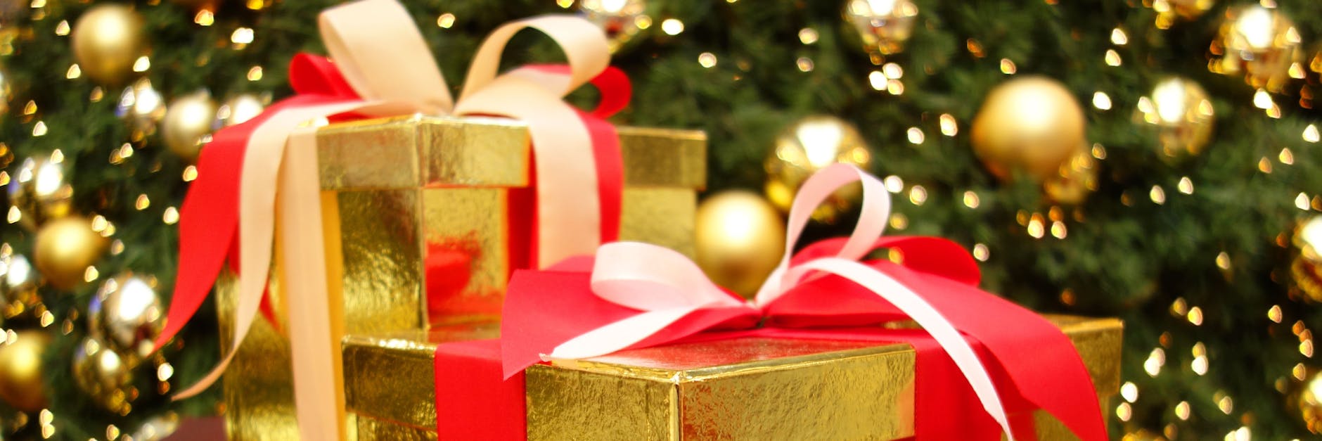 Weihnachtspäckchen mit Schleifen unter einem Weihnachtsbaum dekoriert (Symbolfoto).