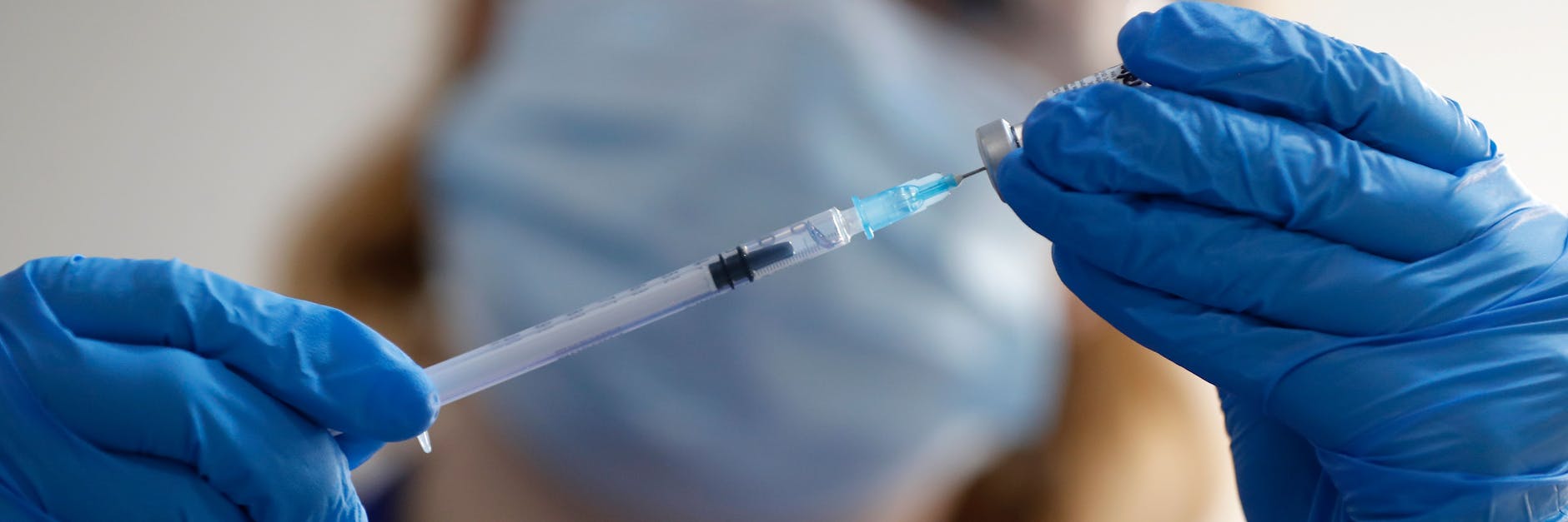 Eine Spritze wird mit dem Corona-Impfstoff von Biontech und Pfizer aufgezogen.