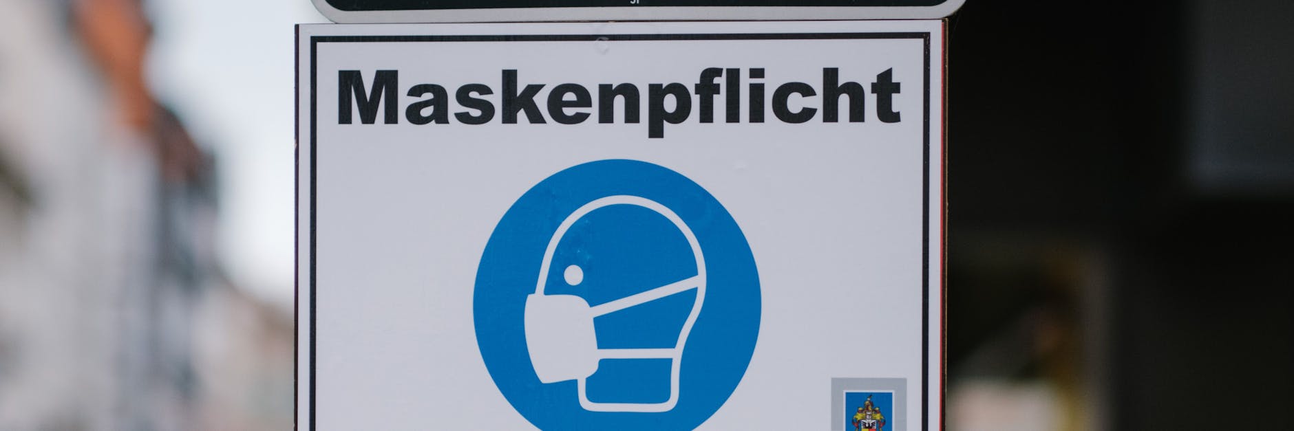 Ein Schild weist auf die Maskenpflicht hin.