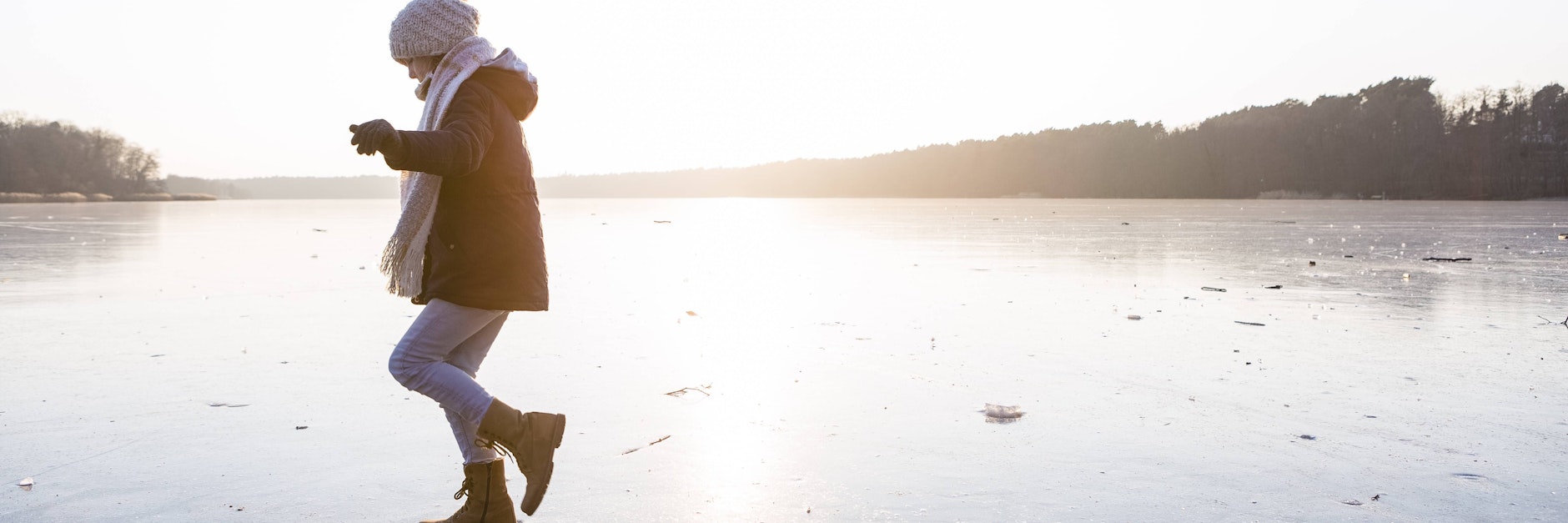 Ein Mädchen läuft über einen zugefrorenen See in Brandenburg (Archivbild).