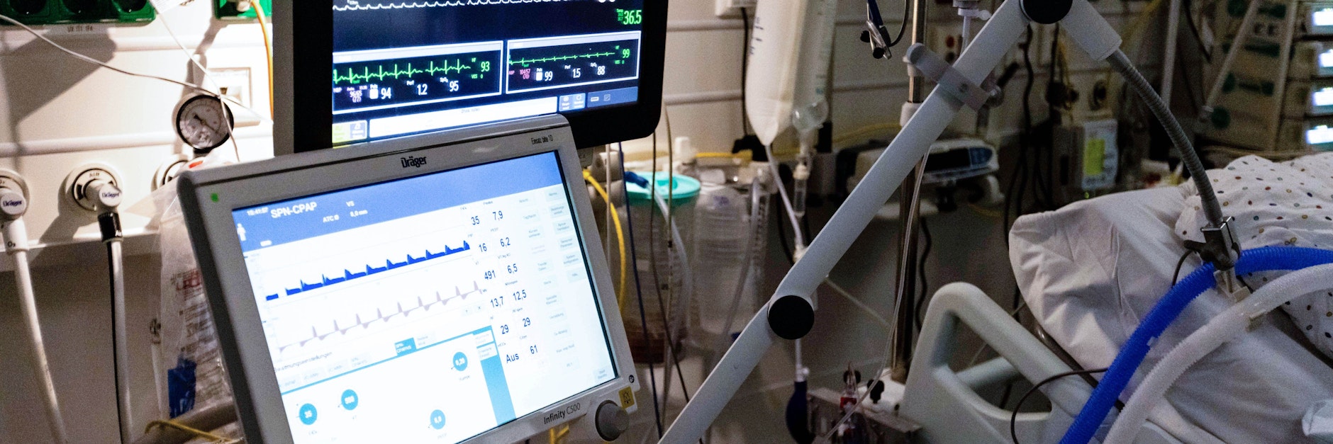 Ein Beatmungsgerät steht an einem Krankenbett.