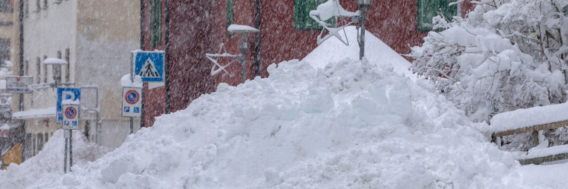 Am Straßenrand des Ortes Brenner in den Alpen wurde geräumter Schnee meterhoch aufgetürmt.