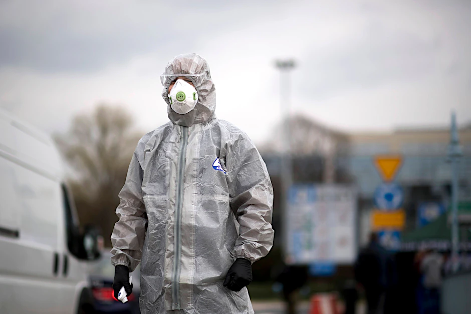 Ein polnischer Grenzschutz- und Gesundheitsbeamter in Schutzkleidung misst die Temperatur von polnischen Bürgern zwischen Frankfurt an der Oder und Slubice in Polen.