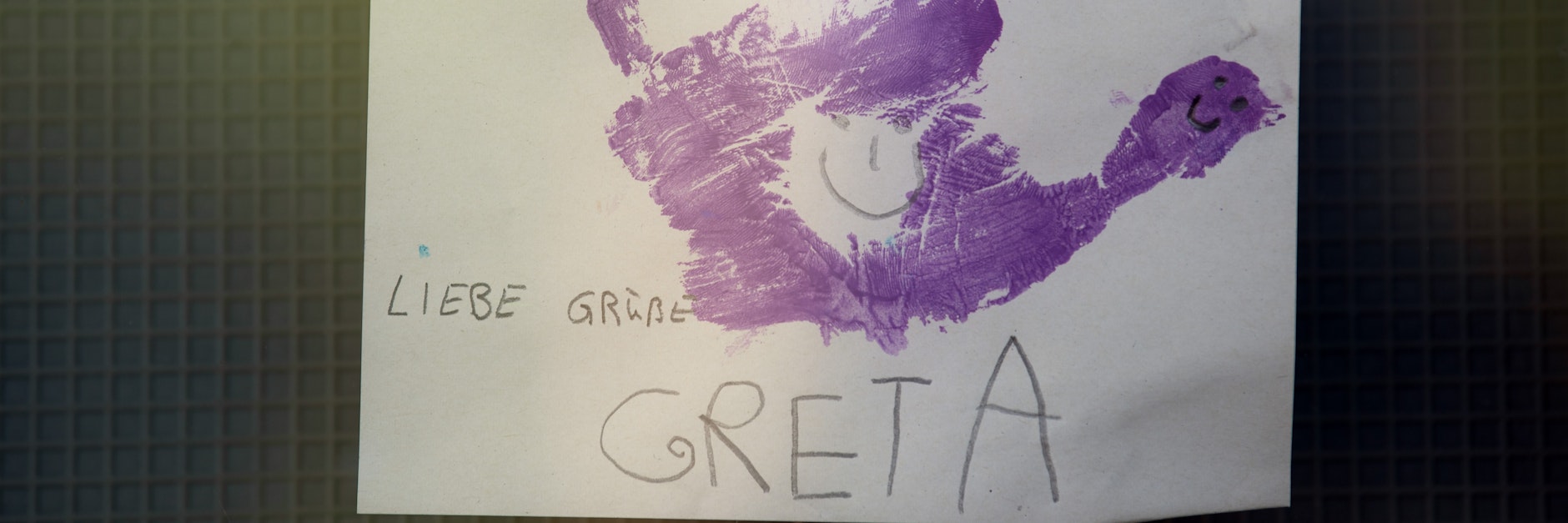 Ein Andenken an die gestorbene Greta (3). Ein Zettel mit dem Handabdruck eines Kindes und der Aufschrift „Liebe Grüße Greta" hängt im Eingangsbereich einer Kita.
