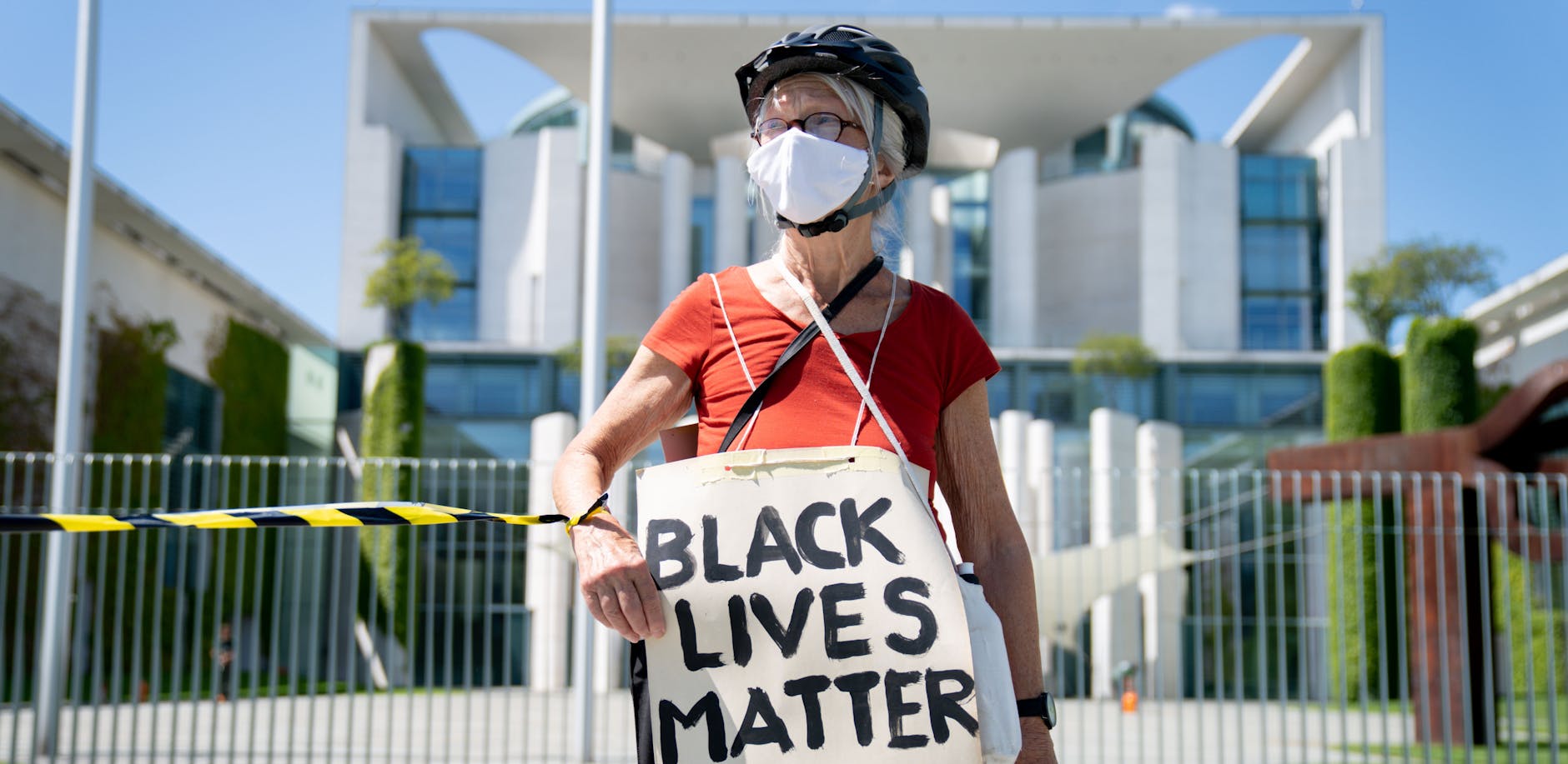 Eine Frau der Anti-Rassismus-Proteste mit Mundschutz vor dem Kanzleramt. Berlins Innenminister Geisel sieht in der Demonstration gegen soziale Ungleichheit und Rassismus wichtige Anliegen - pocht jedoch auf die Einhaltung "klarer Regeln". 