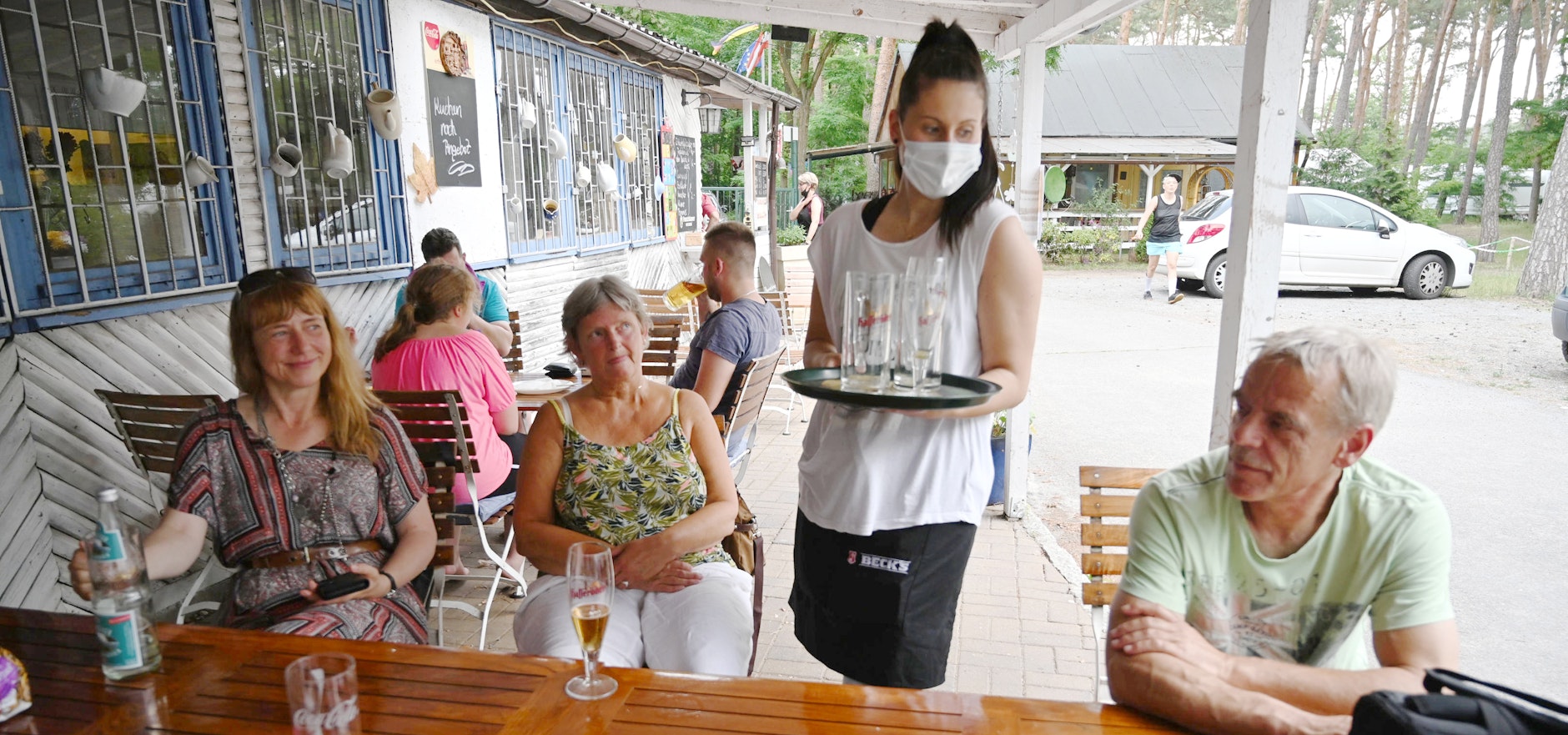 Eine Servicekraft trägt Mundschutz beim Bedienen der Camper.<br>
