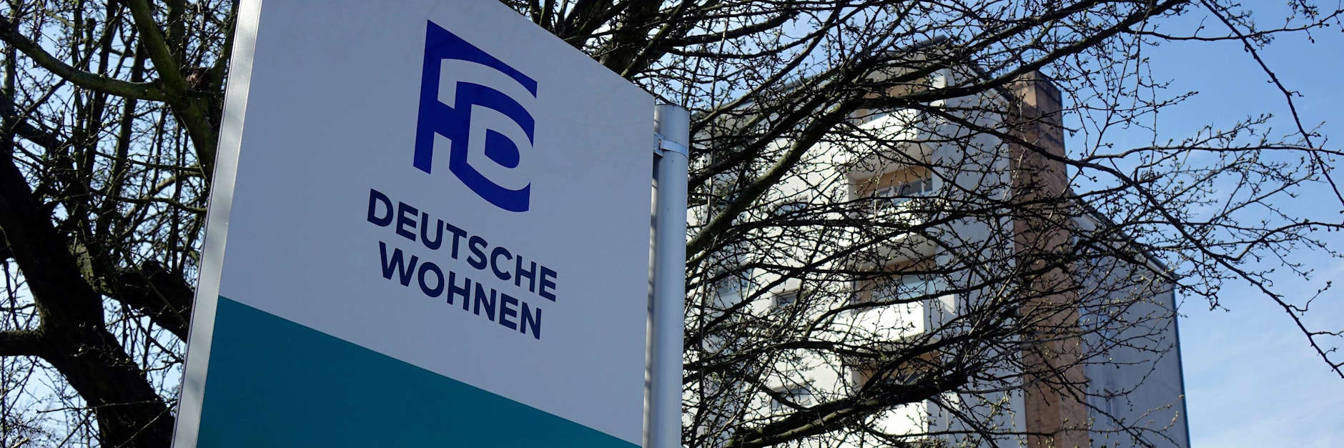 Ein Wegweiser von Deutsche Wohnen zeigt zu einem Service Point.