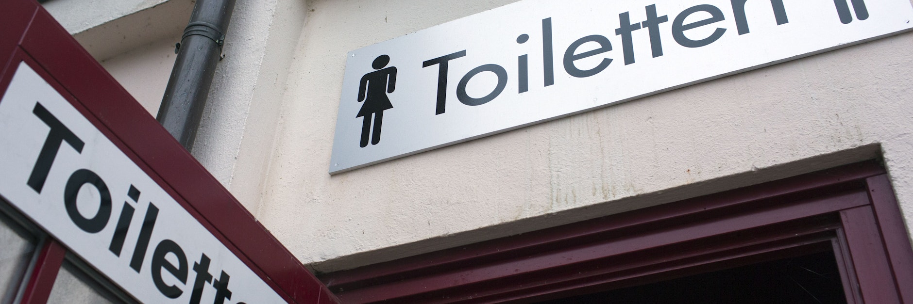 Hinweisschilder sind an der Tür zur öffentlichen Toilettenanlage zu sehen. Mehrfach schon wurde bei Corona-Studien Virenmaterial in menschlichen Ausscheidungen gefunden.&nbsp;