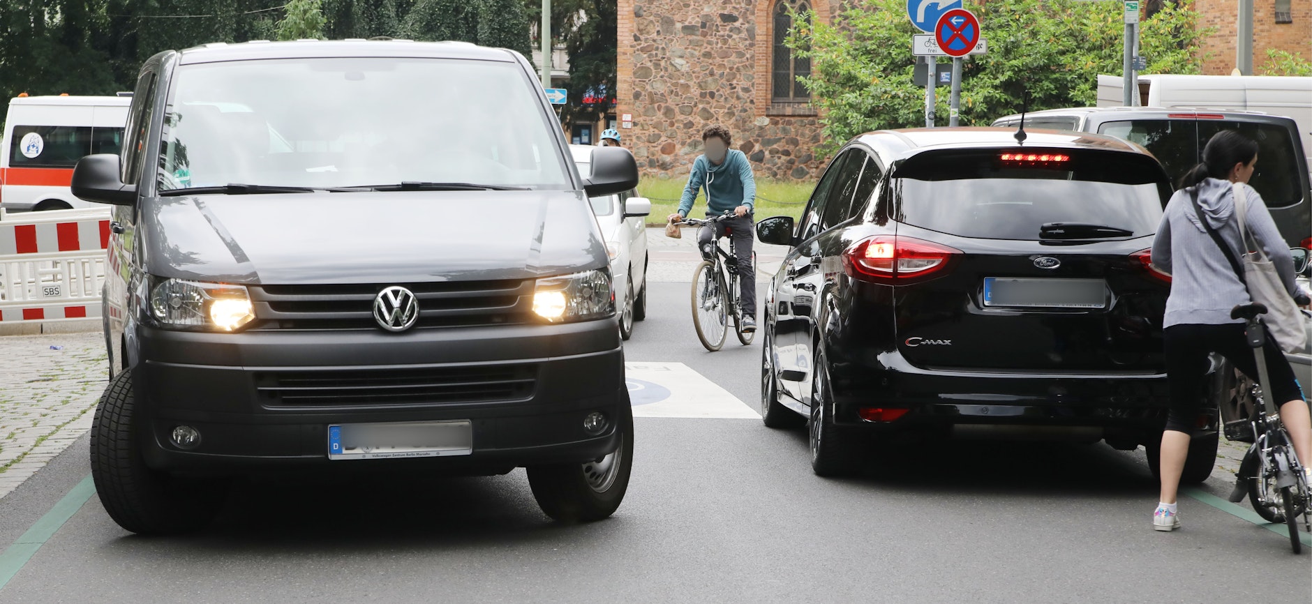 Radfahrer schlängeln sich durch fahrende Autos.&nbsp;
