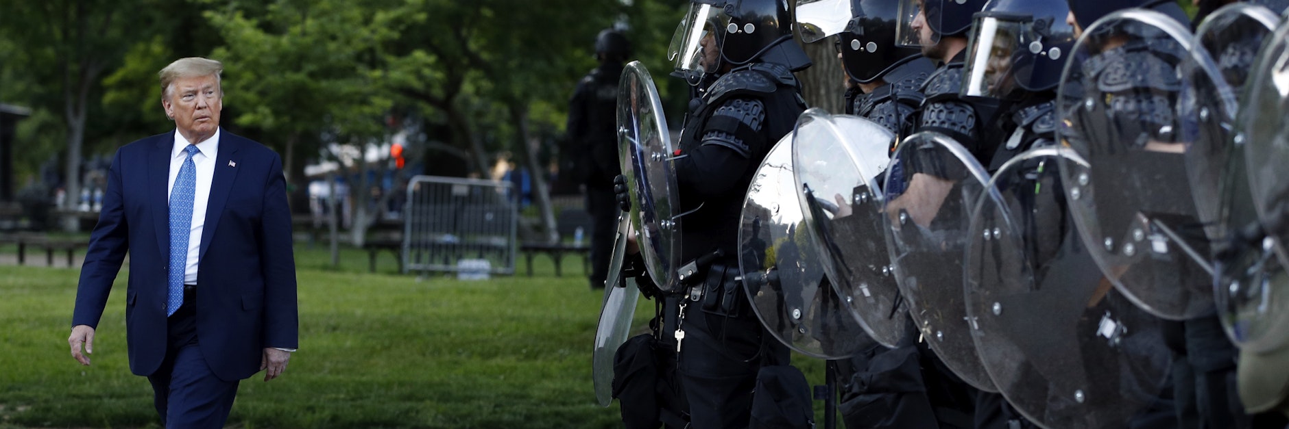 Donald Trump geht in Washington D. C. an Polizisten vorbei, die ihn vor Demonstranten abschirmten. 