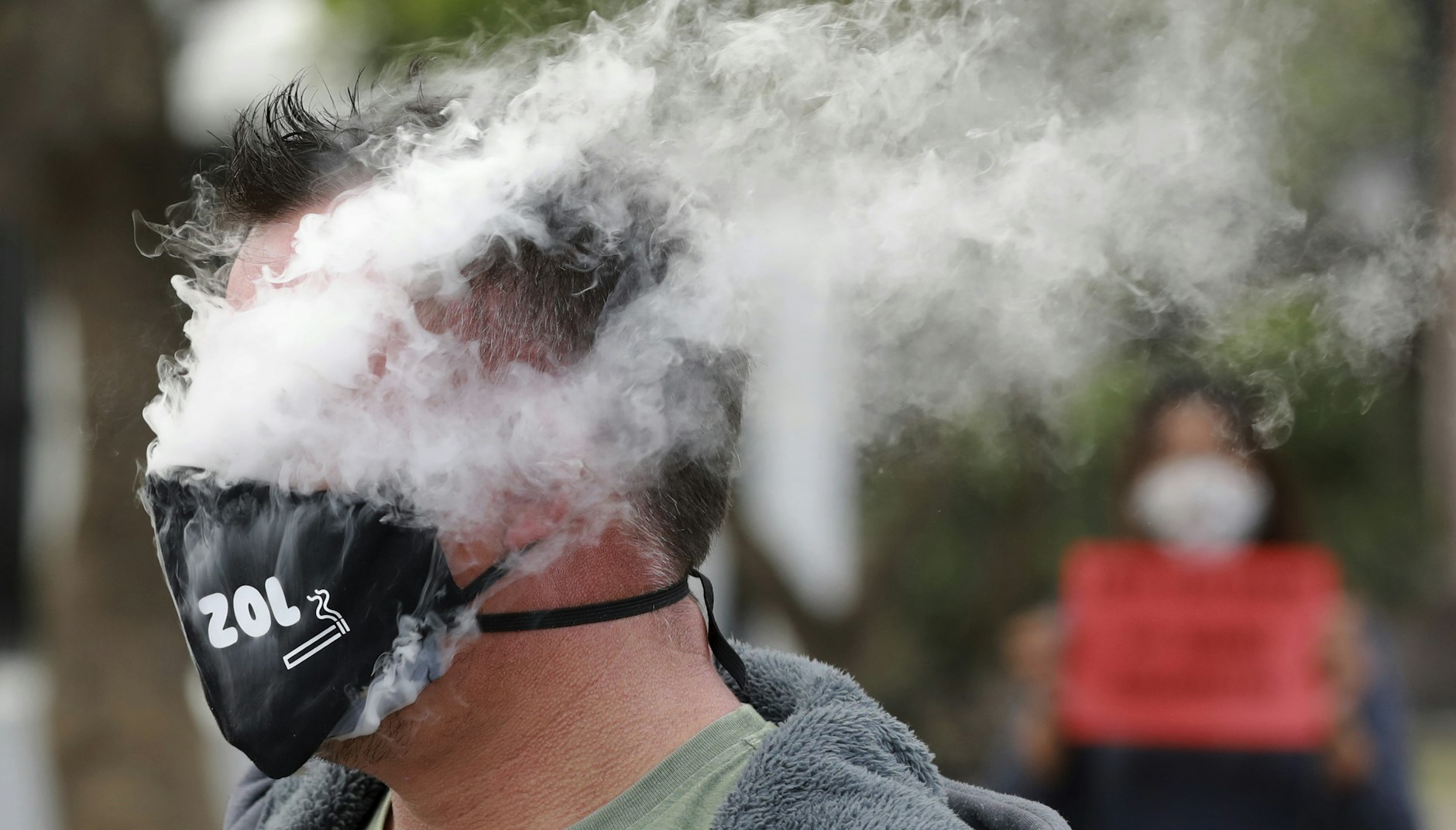 Rauchen mit Maske. Ein Demonstrant protestiert vor dem Parlament in Kapstadt gegen das Tabakverbot.