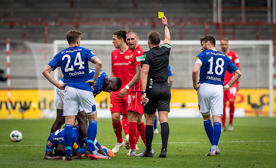Schiedsrichter Tobias Stieler zeigt kein Erbarmen. Der Unparteiische präsentiert Robert Andrich (M.) die Gelbe Karte. Schon seine zehnte Verwarnung der laufenden Spielzeit.