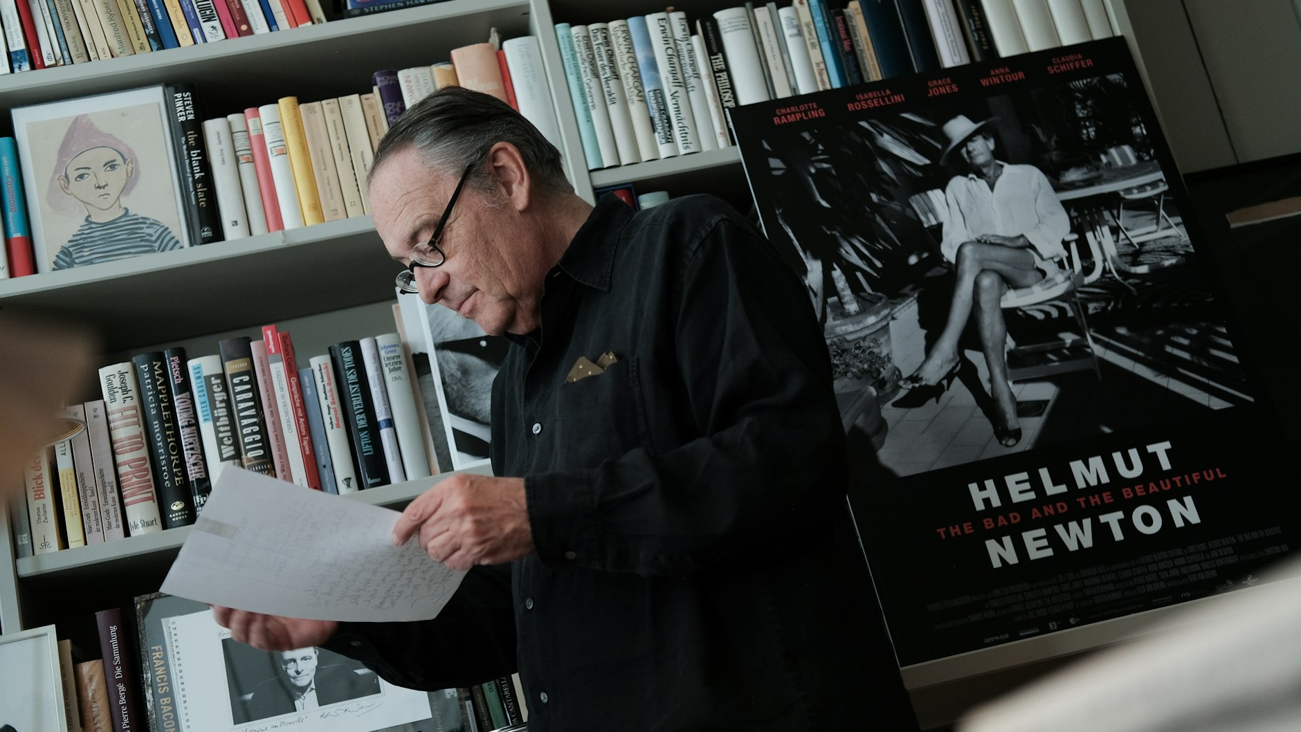 Gero von Boehm mit dem Plakat seines neuen Films. Das dafür verwendete Porträt von Newton mit Damenschuhen schoß Alice Springs alias June Newton 1987 in Monte Carlo. Unter von Boehms rechter Hand guckt er selbst 2002 in Newtons Kamera, als „l'homme au monocle“, so die Widmung des Fotografen darauf.