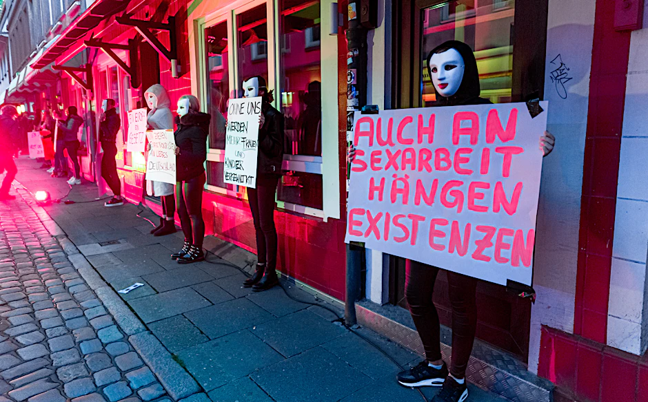 Eine Prostituierte hält in der Herbertstraße ein Schild mit der Aufschrift «Auch an Sexarbeit hängen Existenzen». Sie demonstriert mit anderen Frauen für die Öffnung der coronabedingt geschlossenen Bordelle auf St. Pauli.