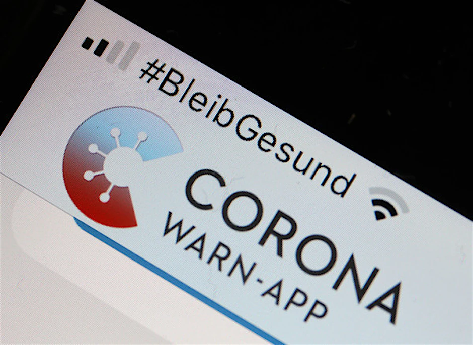 Die Corona-Warn-App mit der Seite zur Risiko-Ermittlung ist im Display eines Smartphone zu sehen.