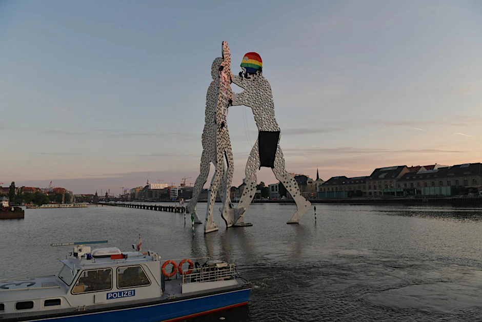 Die linken Kletterer haben einer Figur eine regenbogenfarbene Sturmhaube aufgesetzt. An einer anderen Figur wurde ein Banner angebracht, auf dem steht:&nbsp;„L34 Says– Wohnraum ist keine Ware“