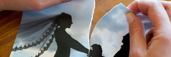 Eine Frau zereisst ihr Hochzeitsfoto.