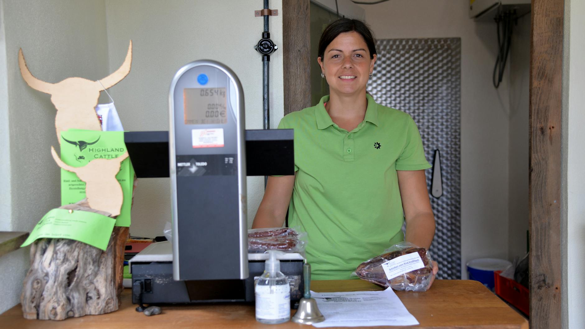 Sarah Grommes steht mit einem Rinderschinken in ihrem kleinen Verkaufsraum. 