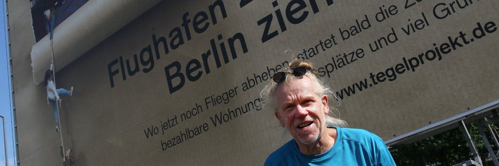 Johannes Hauenstein am Flughafen Tegel. Mit dem Plakat wirbt die Tegel Projekt GmbH für die geplante Umgestaltung des Geländes.